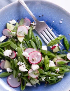 sliced radishes and snap peas topped with feta cheese