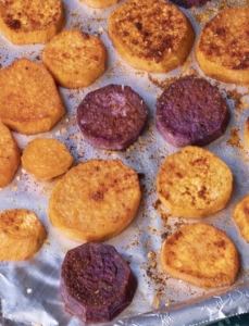 baking tray with sliced sweet potatoes covered in spices