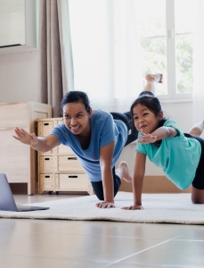 A mother and daughter exercise together at home