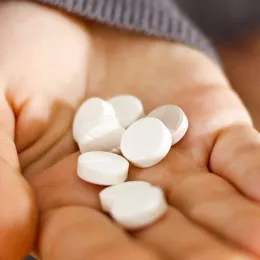 woman holding pills in hand