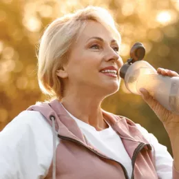 woman drinking out of a sports bottle