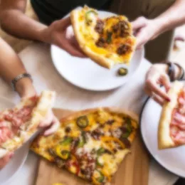 people eating pizza around table