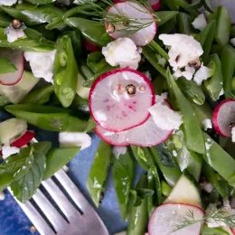 sliced vegetables on a plate with a fork