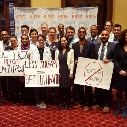 A diverse group holding signs supporting sugar free kids