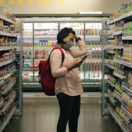 A woman in a grocery store peruses the snack aisle