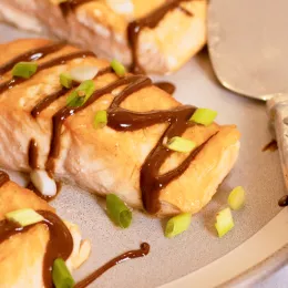 salmon drizzled with black garlic sauce and scallions