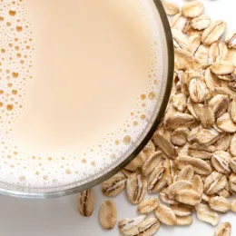 view from above, cup of oat milk with pile of oats next to it 