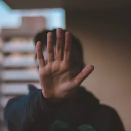 Man holding his hand up to signify "pause" or "stop"