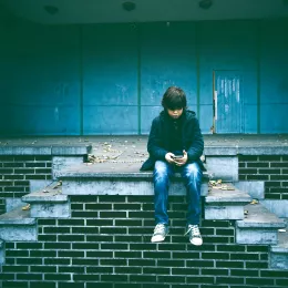 A middle school aged boy watching a video on his phone