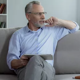 Man sitting on a couch looking out of a window