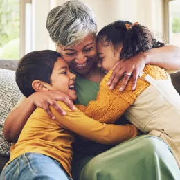 older woman hugging 2 younger children