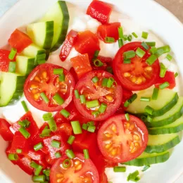 bowl filled with tomatoes, cucumbers and cottage cheese