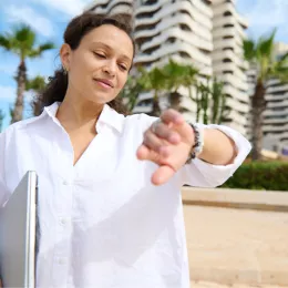 woman standing outside and looking at her watch