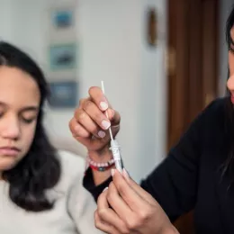 Mother following the instructions to collect a sample of the covid test result at home