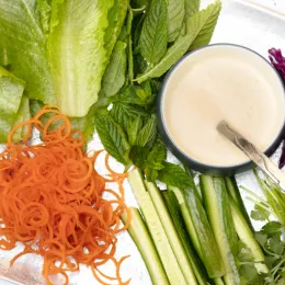 tray filled with different lettuce and chopped vegetables and sauce