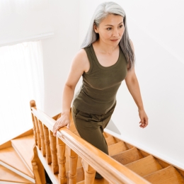 older woman climbing wooden stairs