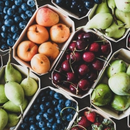 Seasonal produce - Flat-lay of ripe strawberries, cherries, grapes, blueberries, pears, apricots, figs in wooden eco-friendly boxes