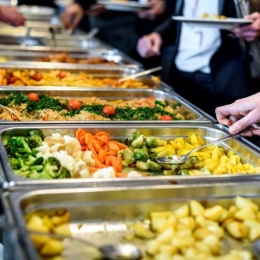 Employees at an office cafeteria choose healthy foods for lunch at work