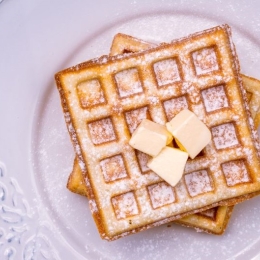 Prepared frozen waffles; flat lay on a white ceramic plate with butter