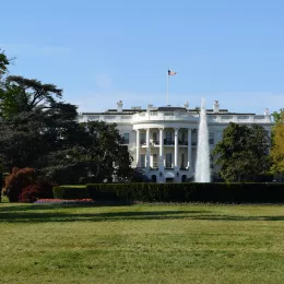 A picture of a large green lawn with the White House in the background