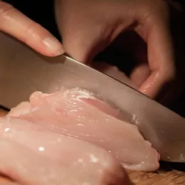 cutting raw chicken