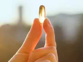 a hand holding a vitamin d pill