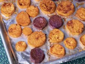 baking tray with sliced sweet potatoes covered in spices