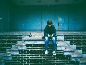 A middle school aged boy watching a video on his phone