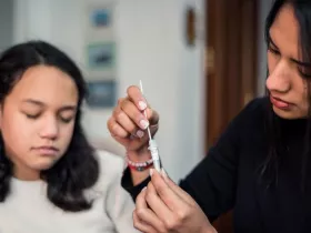 Mother following the instructions to collect a sample of the covid test result at home