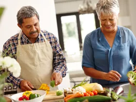 a man and a woman chopping vegetables