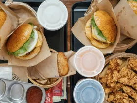 Flat lay of fast food burgers and fried foods with soda