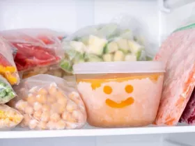 Frozen vegetables in a freezer. A bowl of frozen food with a smiley face drawn in the frost