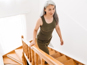 older woman climbing wooden stairs