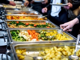 Employees at an office cafeteria choose healthy foods for lunch at work