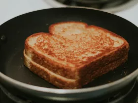 A well toasted grilled cheese sandwich in a frying pan. 