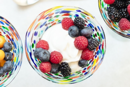 colorful glass bowl holding yogurt and various berries