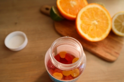 Chewy vitamin C supplements next to a halved orange