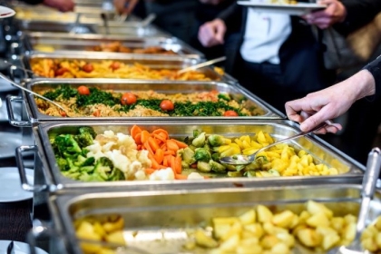 Employees at an office cafeteria choose healthy foods for lunch at work