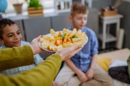 An instructor presents a healthy snack plate of fruit for students at an afterschool meeting