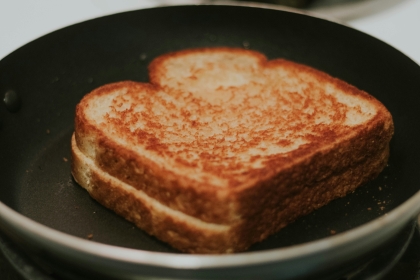 A well toasted grilled cheese sandwich in a frying pan. 