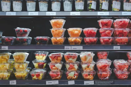 Supermarket shelves containing fruit salad and pre-cut fruits in plastic to go containers