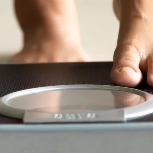 a woman stepping onto a scale