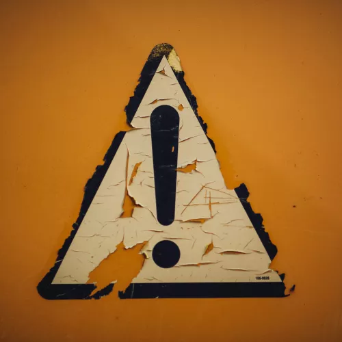 Triangular sign with an exclamation point, conveying "caution"