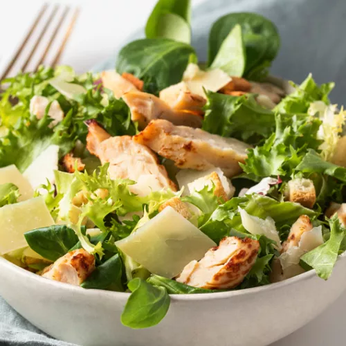 white bowl filled with chicken caesar salad