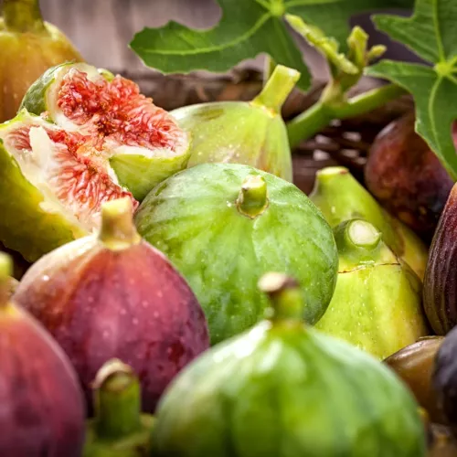 A variety of fresh figs, including red and honey fleshed types, on a table