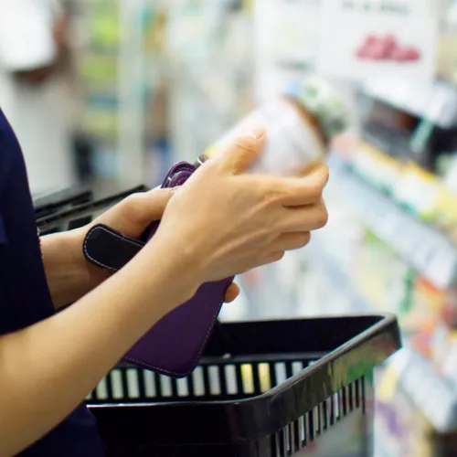 person looking at a vitamin bottle in a store