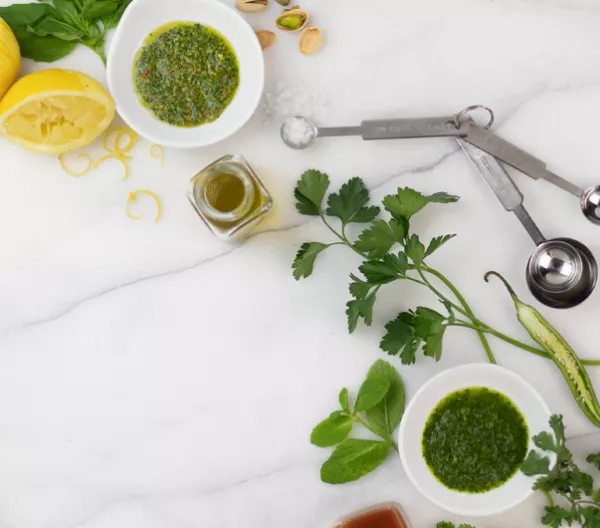 herb sauces with ingredients on marble slab