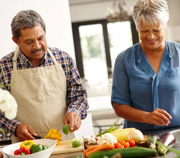 a man and a woman chopping vegetables