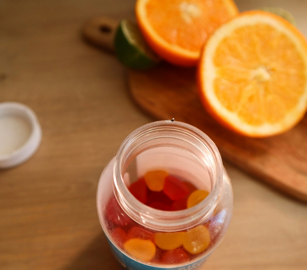 Chewy vitamin C supplements next to a halved orange