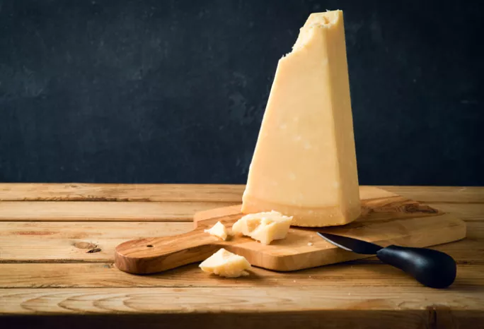 block of cheese on cutting board with knife